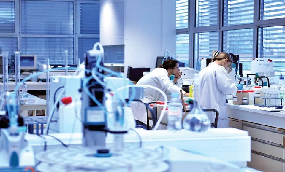Laboratuvar tezgâhında cihazlarla numune analizi yapan laborantlar